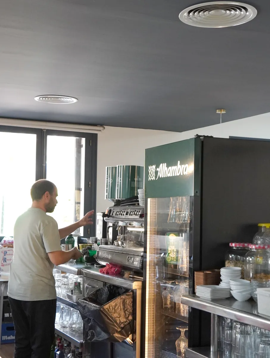 Camarero de El Hogar preparando un café en la máquina de la barra