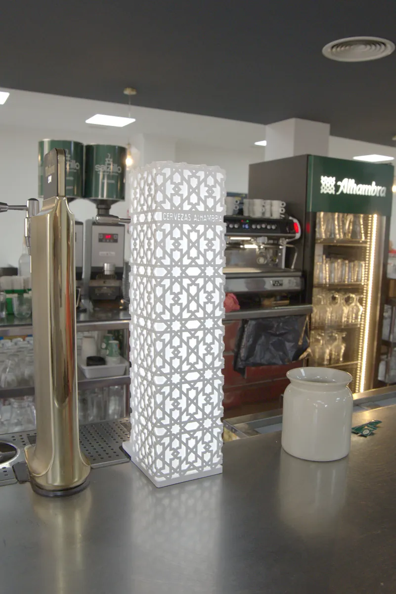 Detalle de la barra del Restaurante El Hogar con el tirador de cerveza y una lámpara de celosía