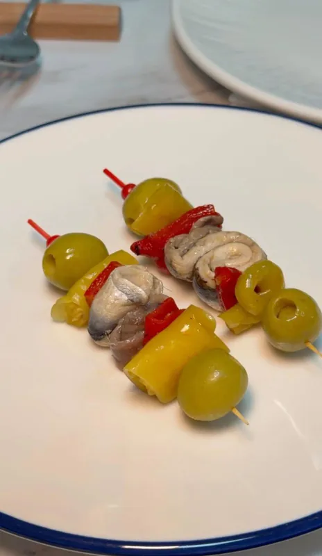 Dos gildas de aceituna, piparra y anchoa en un plato