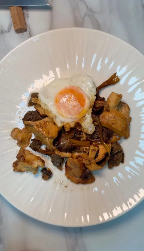 Plato de huevos rotos con setas salteadas del Restaurante El Hogar